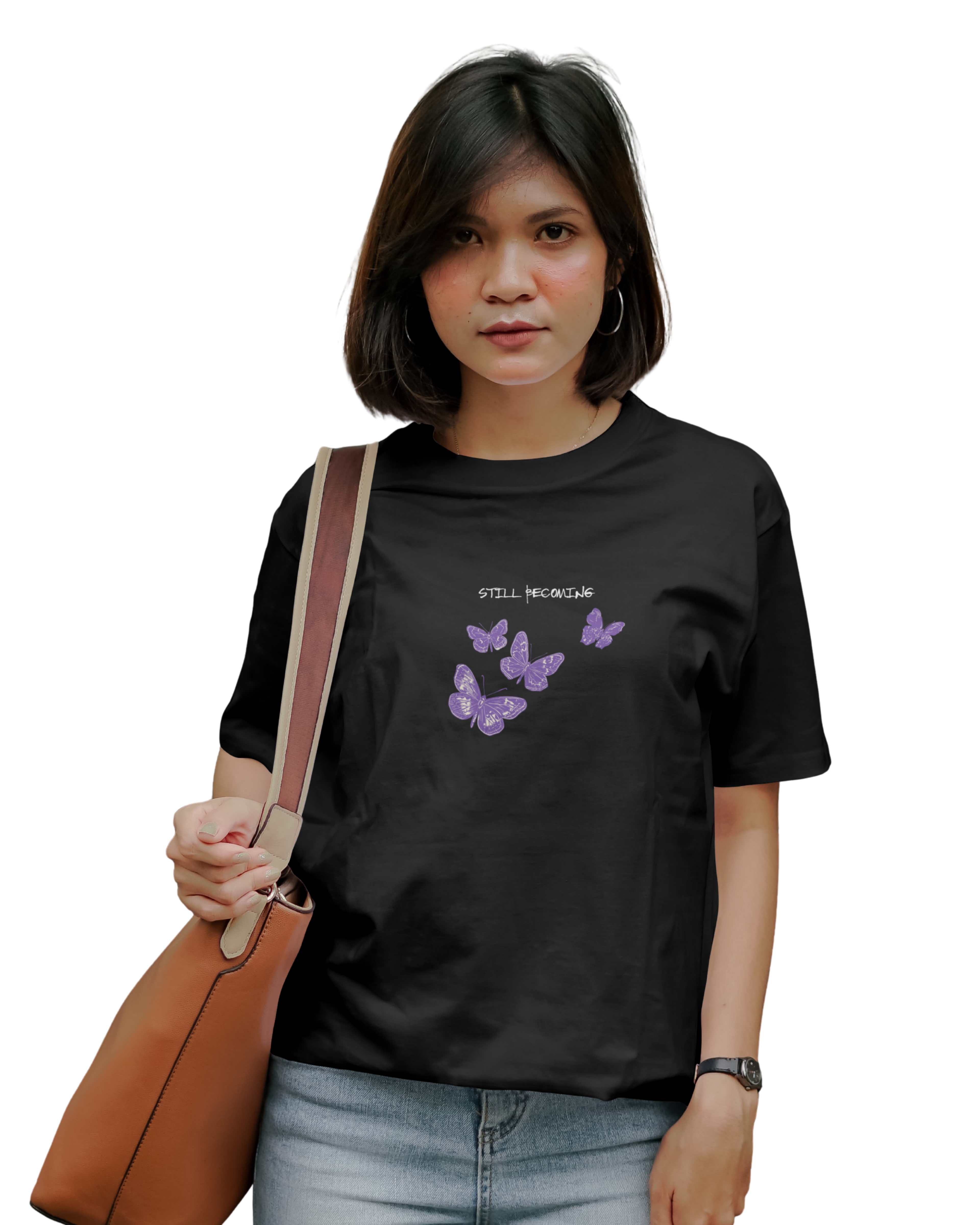 Person wearing a black t-shirt with butterfly designs and text, holding a brown bag.