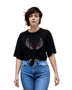 Person wearing a black t-shirt with a design and blue jeans on a white background