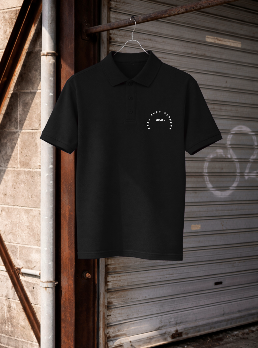 Black polo shirt with a logo on a hanger against a rustic background