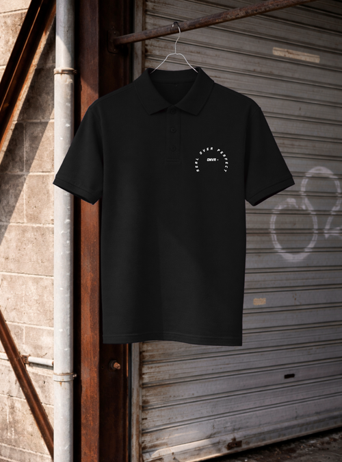 Black polo shirt with a logo on a hanger against a rustic background