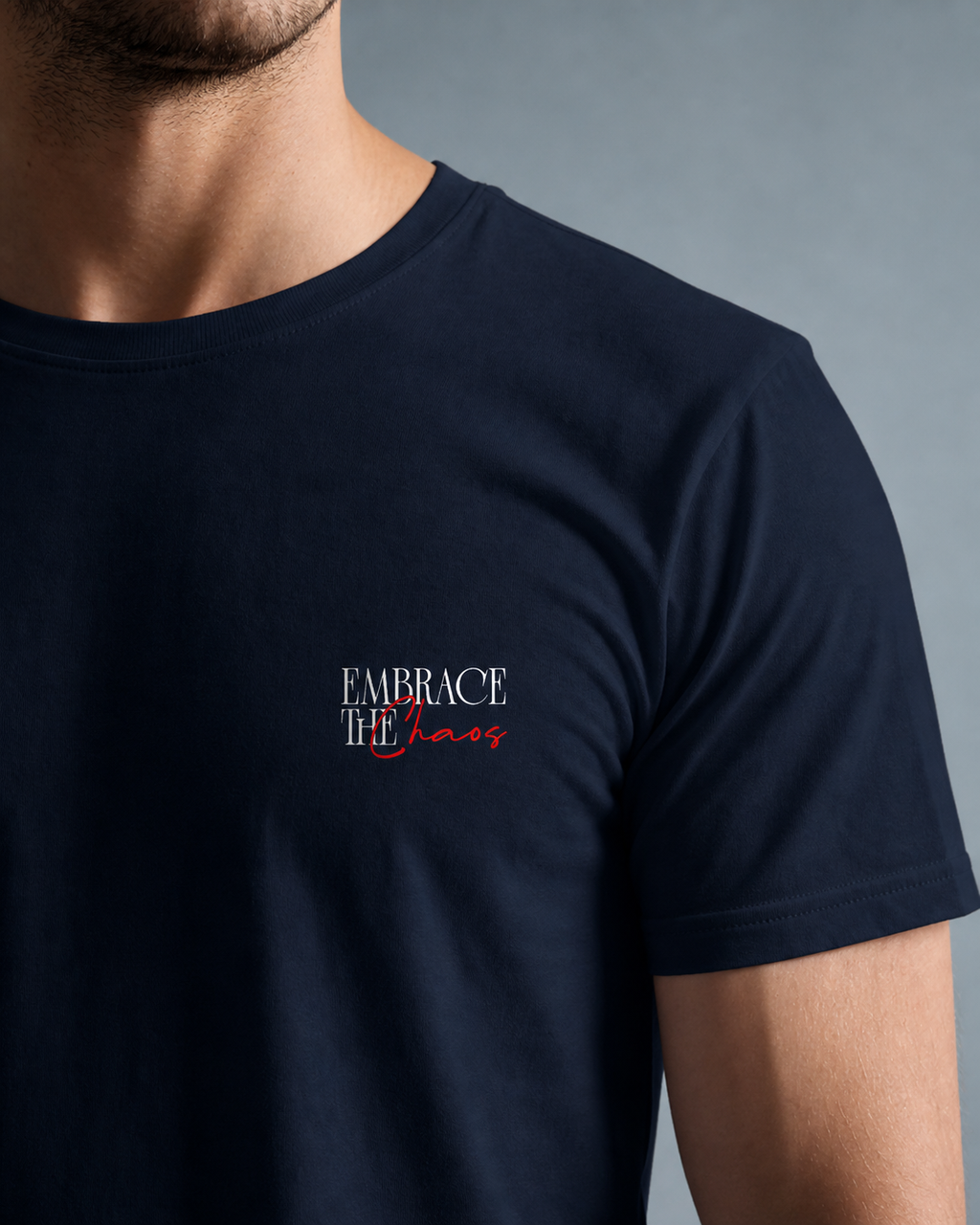 Navy blue t-shirt with 'Embrace the Chaos' text on a gray background