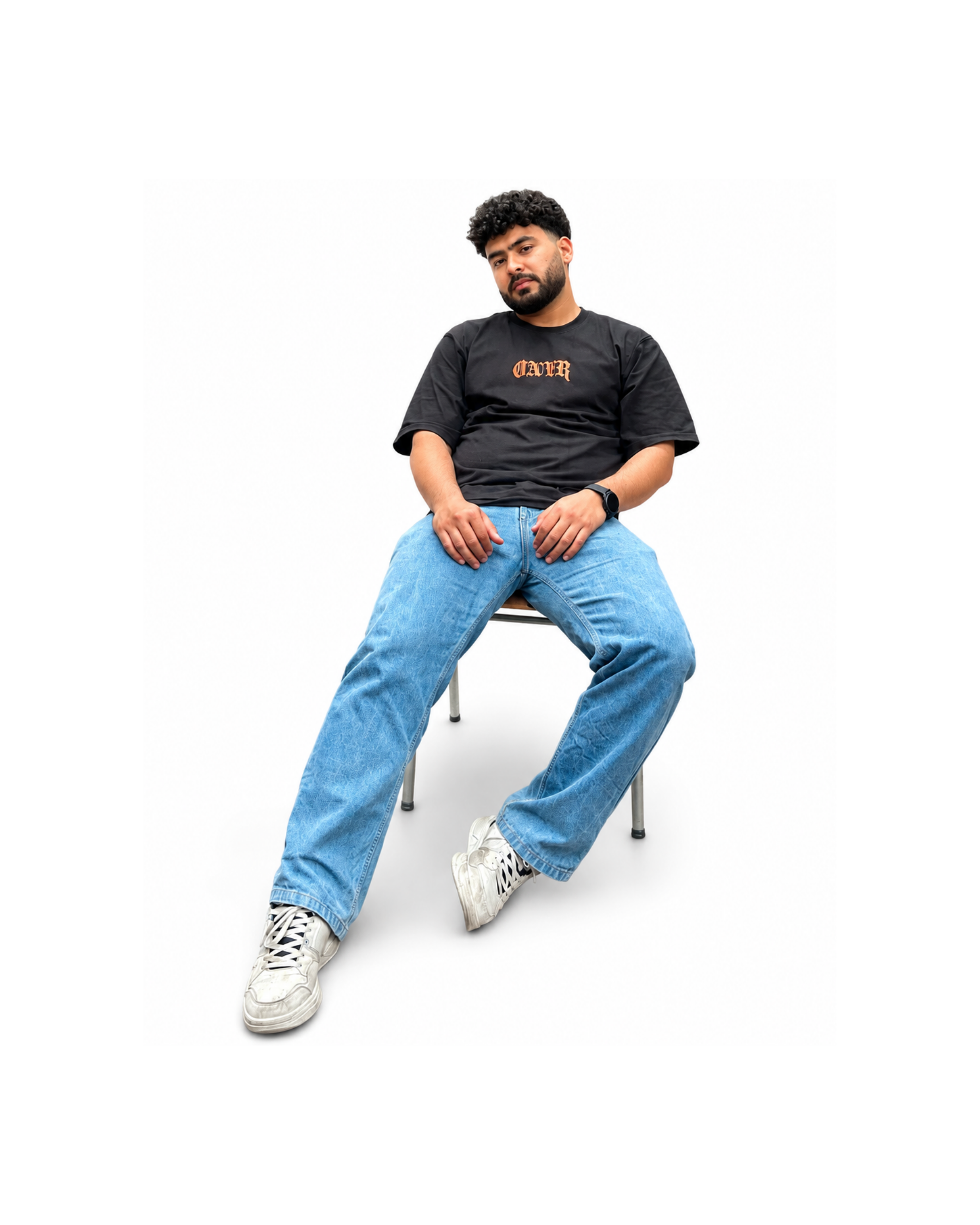 Male model wearing a black oversized graphic t-shirt and relaxed-fit denim, showcasing modern men's streetwear and casual fashion.