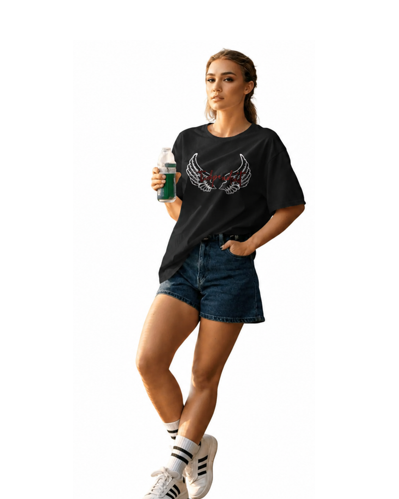 Woman model wearing a ONVR black t-shirt with a graphic design, denim shorts, and white sneakers on a white background