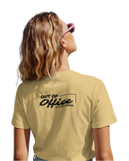 Person wearing a beige t-shirt with 'Out of Office' text on the back, looking up.