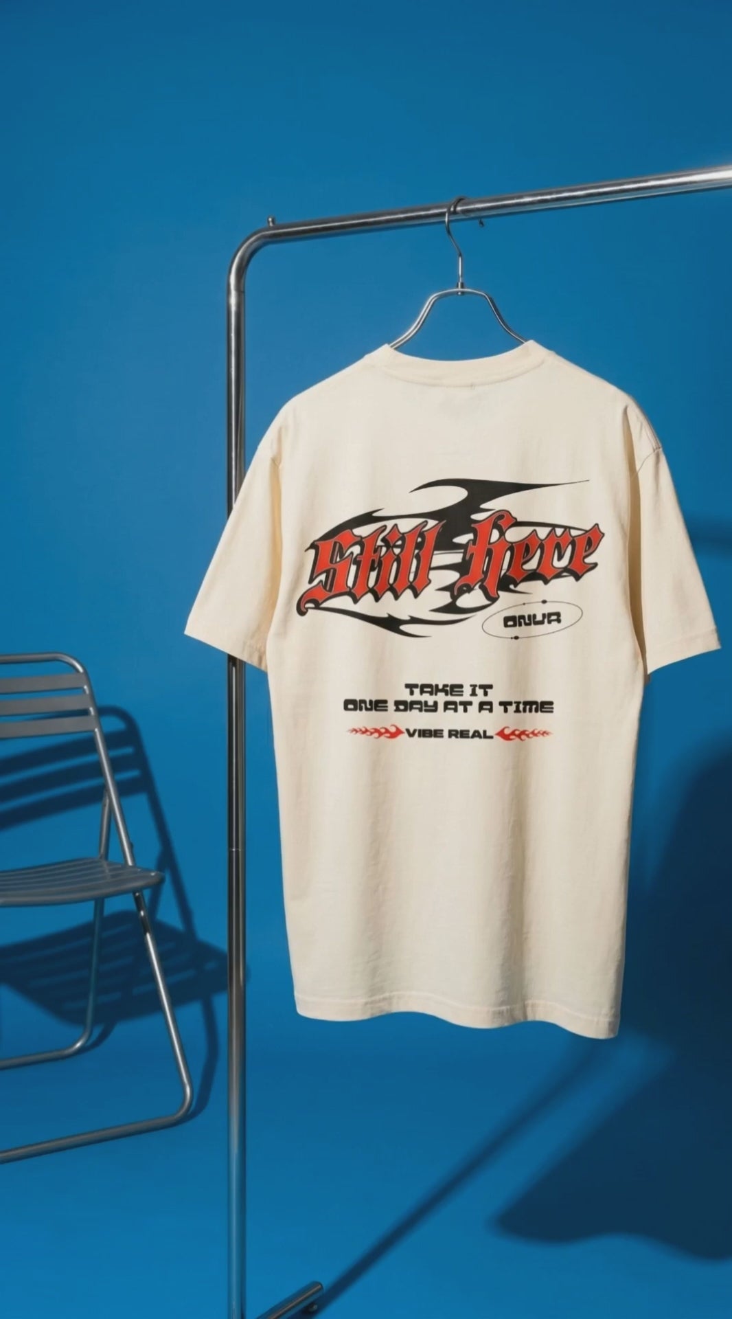 video clip of Off-white t-shirt with red and black text on a hanger against a blue background