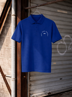Blue polo shirt with a logo hanging on a metal door.
