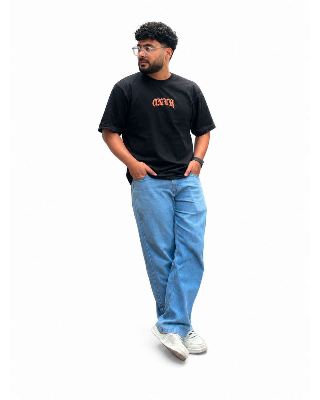 Model wearing a ONVR black t-shirt with orange text, blue jeans, and white sneakers on a white background