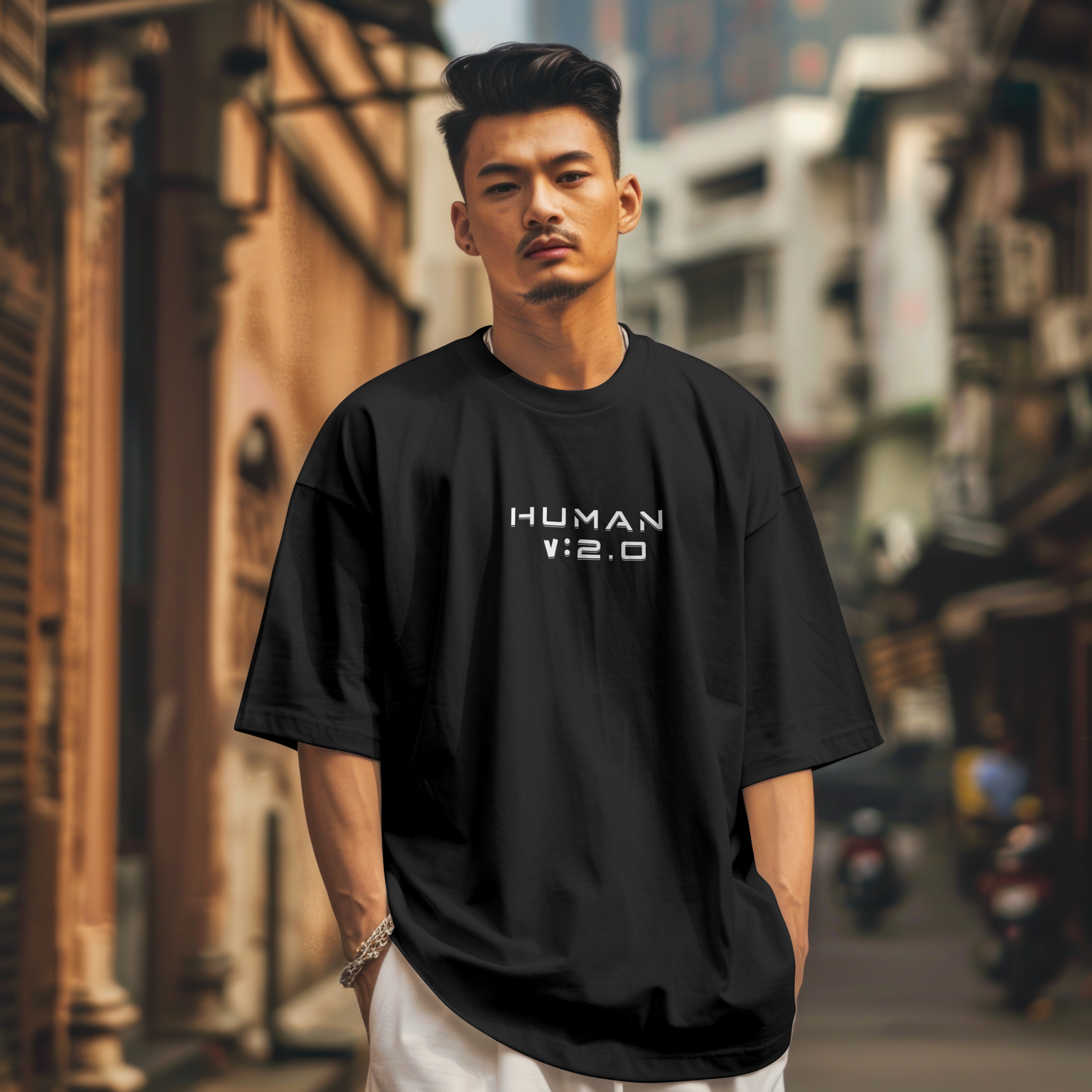 Man wearing a black t-shirt with 'HUMAN V:2.0' text in an urban setting