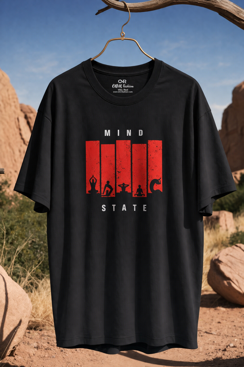 Black t-shirt with red graphic design hanging on a hook against a desert landscape.